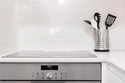 a stove top oven in a kitchen with utensils at LovelyStay - 1BR Flat w AC and Balcony by Aliados in Porto