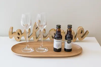 two bottles and two wine glasses on a wooden tray at Kings Oporto Apartments in Porto