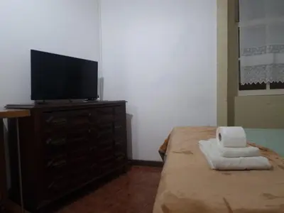 a bedroom with a television on a dresser with towels at Truz truz2 in Porto