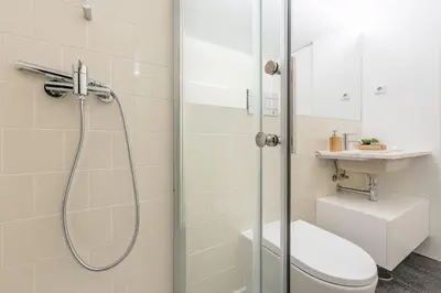 a bathroom with a shower and a toilet and a sink at LovelyStay - Porto Windows with AC by central station in Porto