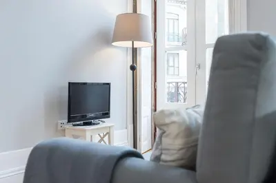 a living room with a couch and a television at LovelyStay - Porto Windows with AC by central station in Porto