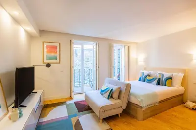 a bedroom with a bed and a chair and a television at Clérigos Tower - Experience in Porto in Porto