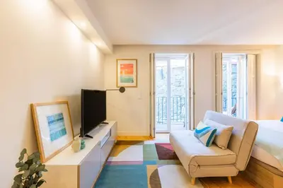 a bedroom with a large bed and a chair at Clérigos Tower - Experience in Porto in Porto