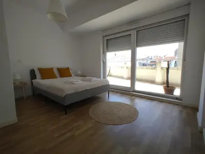 a white room with two beds and a window at Apartamentos Jardim do Morro in Vila Nova de Gaia