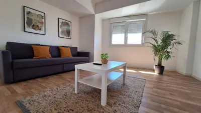 a dining room table with two chairs and a potted plant at Apartamentos Jardim do Morro in Vila Nova de Gaia