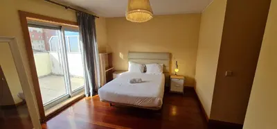 a bedroom with a bed and a large window at Azulejos Apartment in Porto