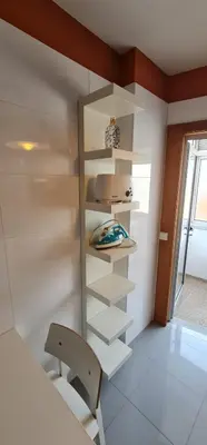 a room with white shelves and a table and a chair at Azulejos Apartment in Porto