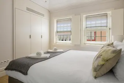 a bedroom with a large white bed with two towels on it at MSC Flat 8 in Porto
