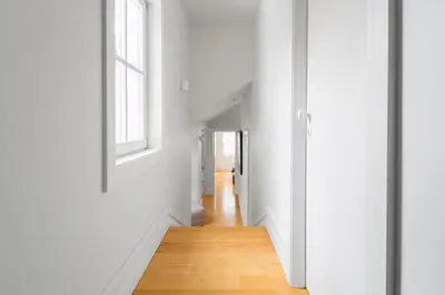 a hallway with white walls and a wooden floor at MSC Flat 8 in Porto