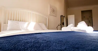 a large bed with a blue blanket and white pillows at Casa do Recanto - Loft vista rio in Porto