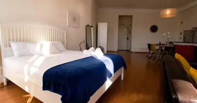 a bedroom with a large bed with a blue blanket at Casa do Recanto - Loft vista rio in Porto