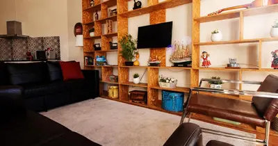 a living room with a couch and a tv at Casa do Recanto - Loft vista rio in Porto