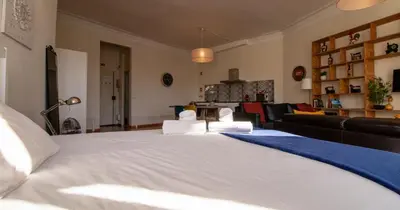 a large white bed in a living room at Casa do Recanto - Loft vista rio in Porto