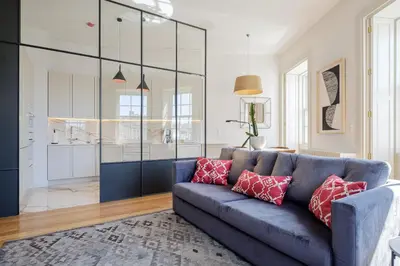 a living room with a blue couch with red pillows at BOUTIQUE Rentals- THE RIBEIRA***** Apt great views in Porto
