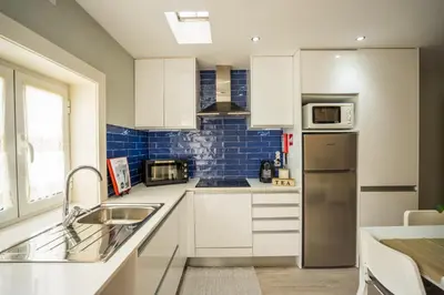 a kitchen with white cabinets and a stainless steel refrigerator at Oporto Explorers in Porto