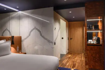 a bedroom with a bed and a marble wall at Forte de Gaia, Autograph Collection in Vila Nova de Gaia