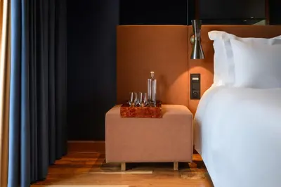 a bed and a side table next to a bed at Forte de Gaia, Autograph Collection in Vila Nova de Gaia