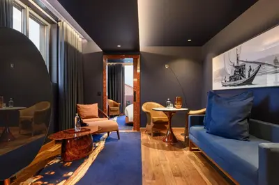 a living room with a blue couch and a table at Forte de Gaia, Autograph Collection in Vila Nova de Gaia