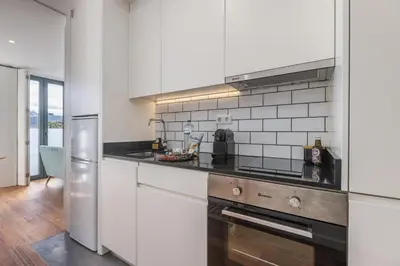 a kitchen with white cabinets and stainless steel appliances at Terrace Bliss with AC Downtown Porto in Porto