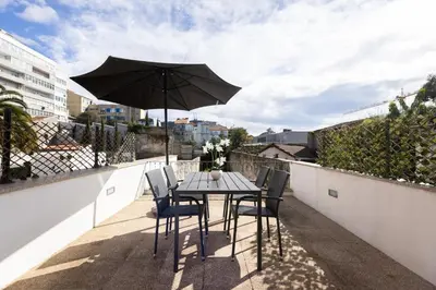 a table and chairs on a balcony with an umbrella at Terrace Bliss with AC Downtown Porto in Porto