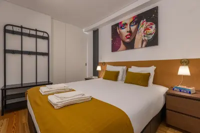 a bedroom with a bed with a painting on the wall at Terrace Bliss with AC Downtown Porto in Porto