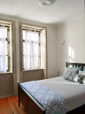 a bedroom with a large bed with two windows at Porto Unique - Apartment with Private Patio in Porto