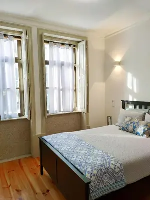 a bedroom with a large bed with two windows at Porto Unique - Apartment with Private Patio in Porto