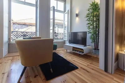 a living room with a chair and a television at Fashion Luxury House in Porto