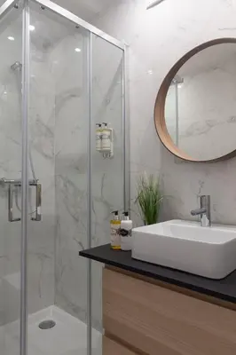 a bathroom with a sink and a shower with a mirror at Fashion Luxury House in Porto