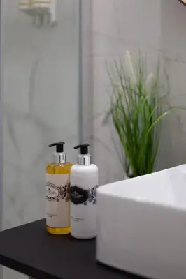 two bottles ofodorizers sitting on a black counter in a bathroom at Fashion Luxury House in Porto