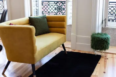 a yellow chair in a living room with a rug at Fashion Luxury House in Porto
