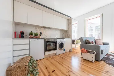 a kitchen and living room with a couch and a washer at GuestReady - Coral Apartment in Porto