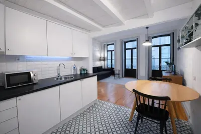 a kitchen with a wooden table and a dining room at Oporto City View - Trindade in Porto