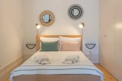 a bedroom with a large bed with two towels on it at Sweety Balcony Porto Center in Porto