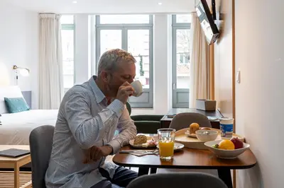 a man sitting at a table with a plate of food at Feel Porto Corporate Housing Marquês in Porto