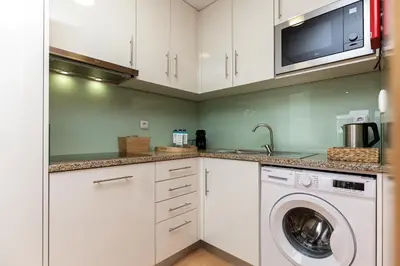 a kitchen with a washing machine and a microwave at Feel Porto Corporate Housing Marquês in Porto