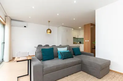 a living room with a gray couch with blue pillows at Feel Porto Corporate Housing Marquês in Porto