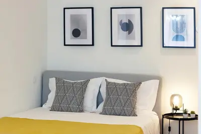 a bedroom with a bed with four pictures on the wall at HM - Sta. Catarina Charming Apartment in Porto