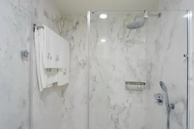 a bathroom with a shower with white marble walls at HM - Sta. Catarina Charming Apartment in Porto