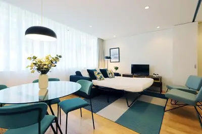 a living room with a table and blue chairs at HM - Sta. Catarina Charming Apartment in Porto
