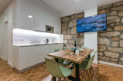 a kitchen and dining room with a wooden table and chairs at GuestReady - Grandeur River Balcony Reborn in Porto