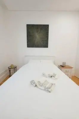 a white bed with a picture on top of it at Warmly Porto in Porto