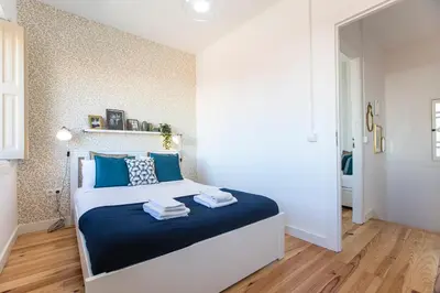 a bedroom with a large bed with blue pillows at Vila Burgães by LovelyStay in Porto