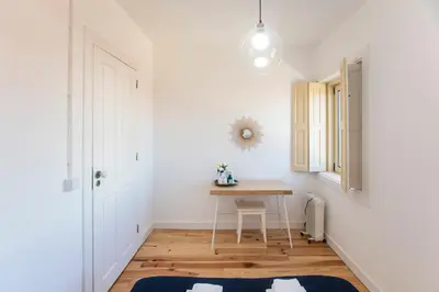 a small dining room with a table and a window at Vila Burgães by LovelyStay in Porto