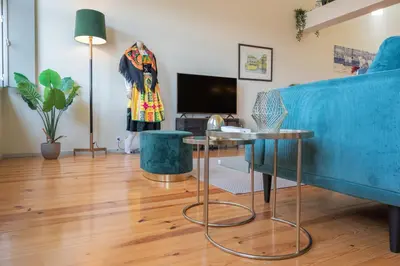 a living room with a blue couch and a table at History Porto in Porto