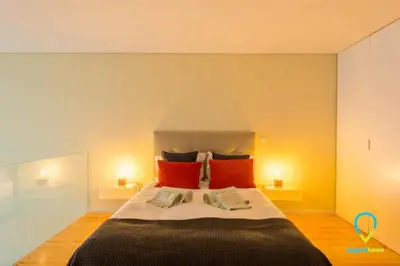 a bedroom with a large bed with red pillows at Pretty Porto in Porto