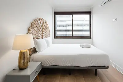 a bedroom with a bed with a lamp and a window at GuestReady - Mystic Subdual in Porto