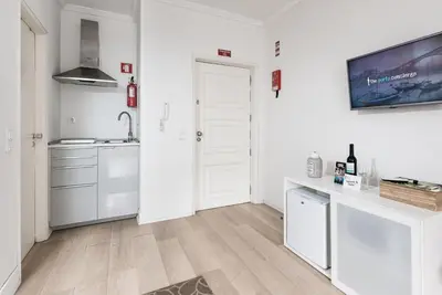 a white kitchen with a sink and a counter at GuestReady - Mystic Subdual in Porto
