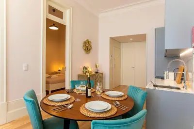 a dining room with a wooden table and blue chairs at LovelyStay - 2BR Flat with AC in Duque de Loulé in Porto