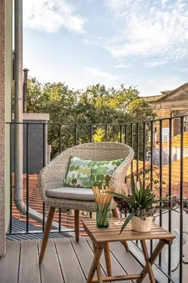 a wicker chair sitting on a deck with a table at Jasmine Loft in Porto